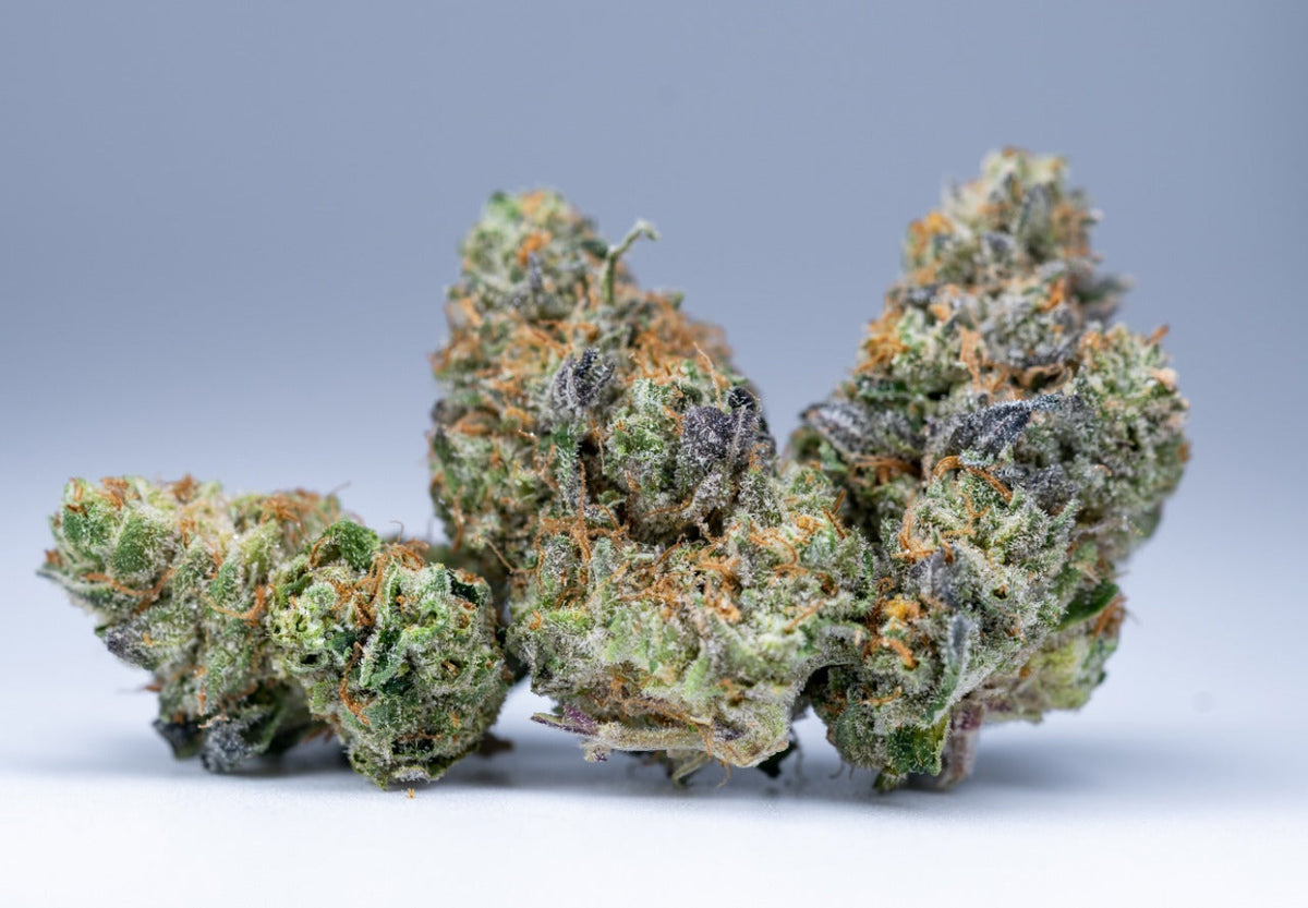 Cannabistoppen met kristallijne trichomen tegen een neutrale achtergrond