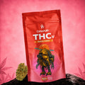 Canapuff THCv Bloemen Papaya Punch 50%, zakje van 1 gram op roze achtergrond